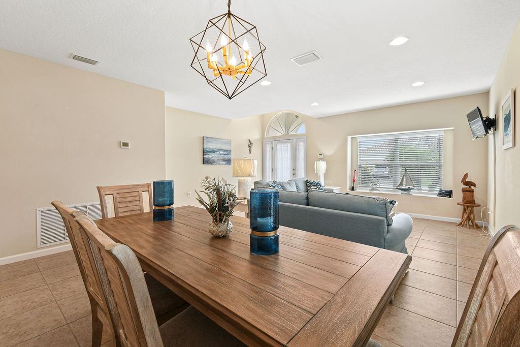 1728 Berkshire Circle Southwest Vero Beach, FL 32968 - Photo 9 of 36 a view of a dining room with furniture a chandelier and wooden floor