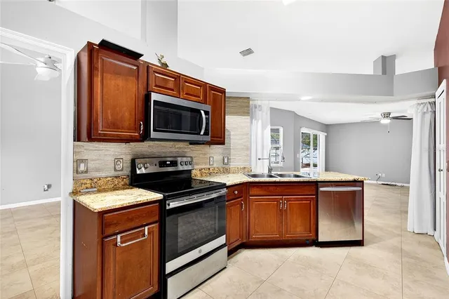 a kitchen with stainless steel appliances granite countertop a sink stove and microwave