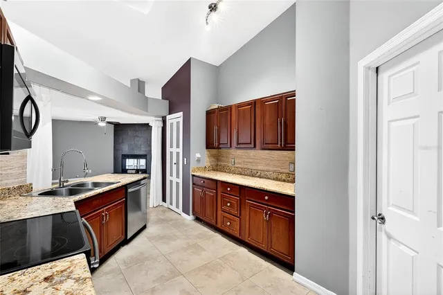 a large kitchen with stainless steel appliances granite countertop a stove and a sink