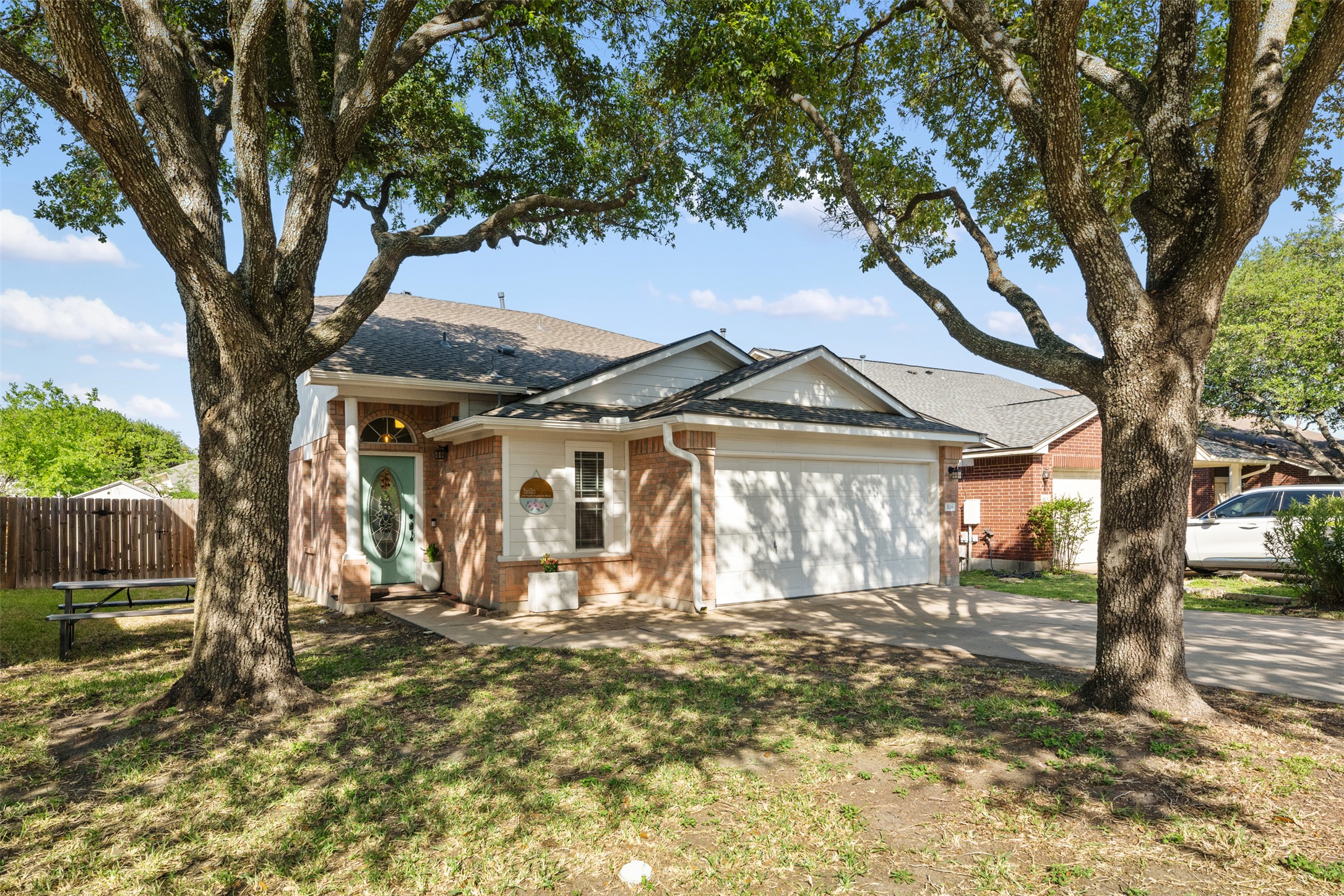 Front of home with large shade trees.
