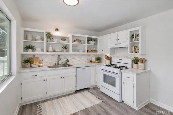 a kitchen with granite countertop white cabinets and white appliances