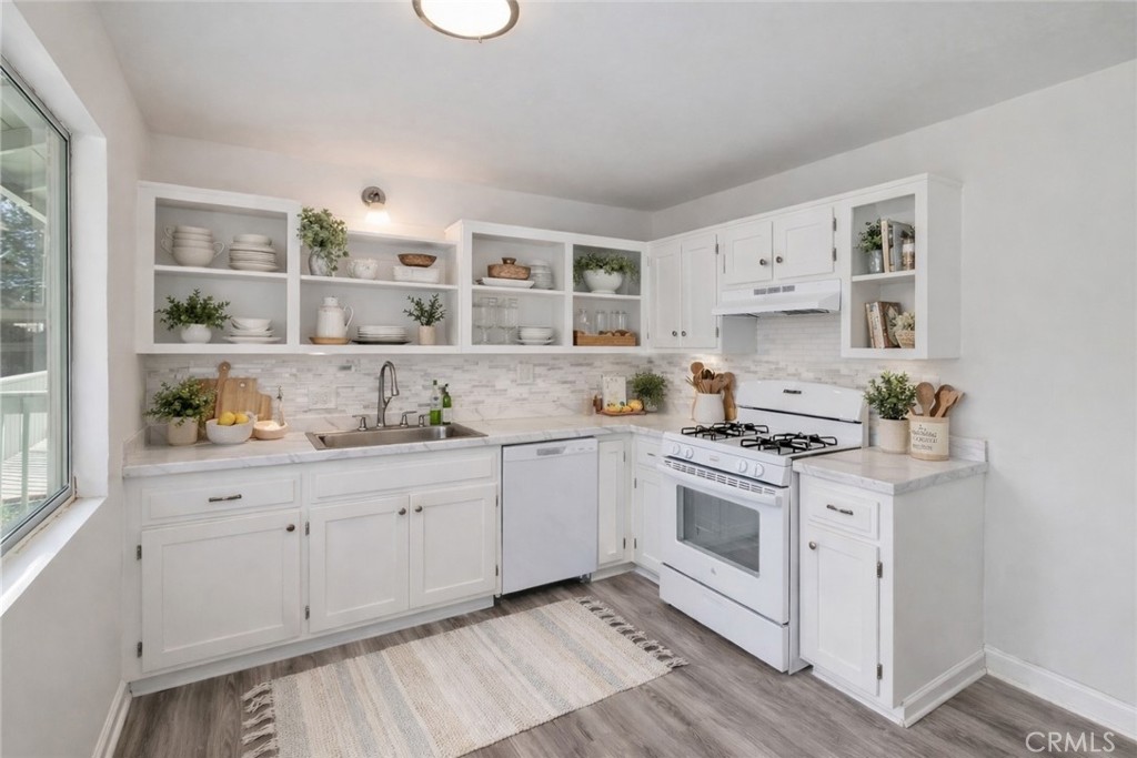 32142 Hunsaker Way Running Springs, CA 92382 - Photo 5 of 51 a kitchen with granite countertop white cabinets and white appliances