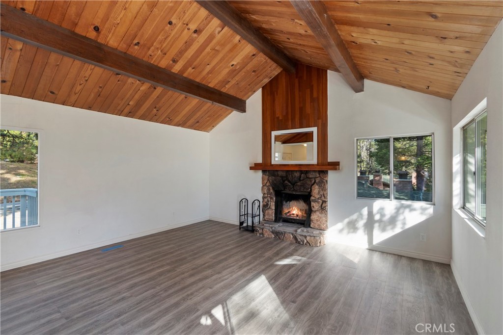 32142 Hunsaker Way Running Springs, CA 92382 - Photo 6 of 52 a view of an empty room with wooden floor fireplace and a window