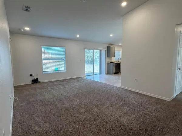 an empty room with windows and fireplace