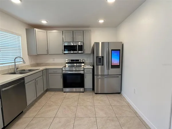 a kitchen with stainless steel appliances granite countertop a stove a sink and a refrigerator