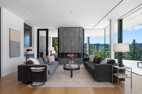a dining hall with stainless steel appliances granite countertop a table chairs and a living room view