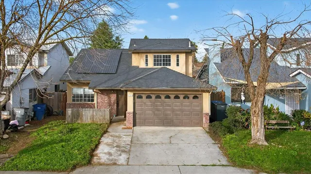 a front view of a house with a yard and garage