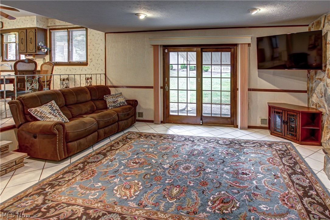 6013 Rousseau Drive Parma, OH 44129 - Photo 10 of 50 Tiled family room with ceiling fan and a textured ceiling