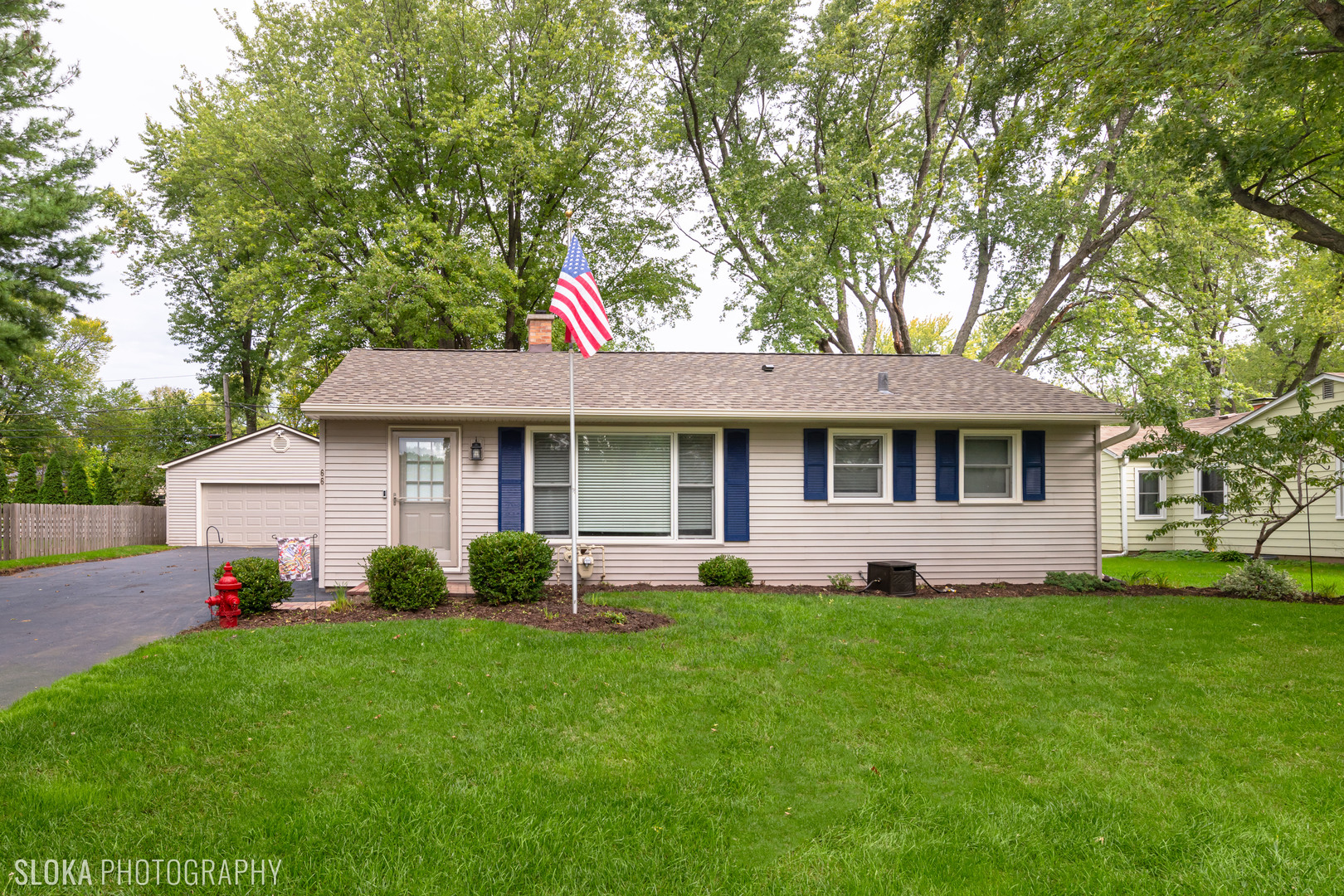 a front view of a house with a garden and yard