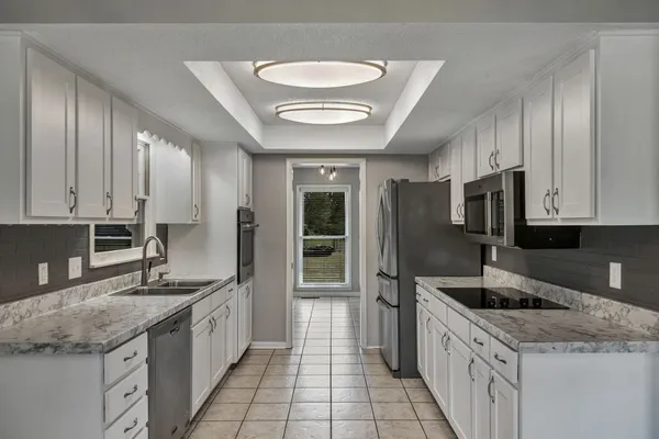 a kitchen with stainless steel appliances granite countertop a stove refrigerator and cabinets