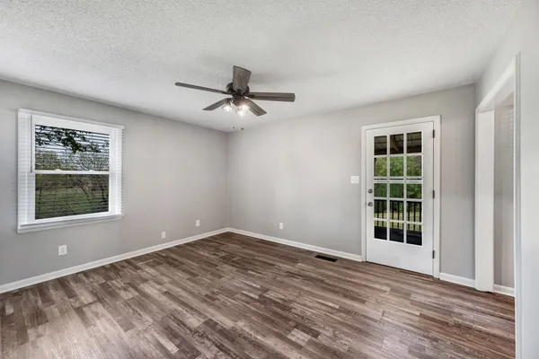 a view of a livingroom with wooden floor and a ceiling fan