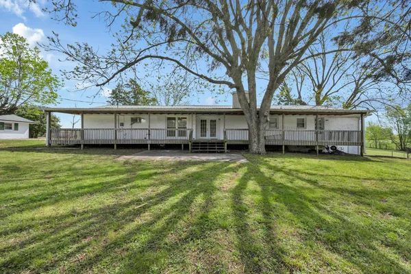 a view of a house with a yard and wooden fence