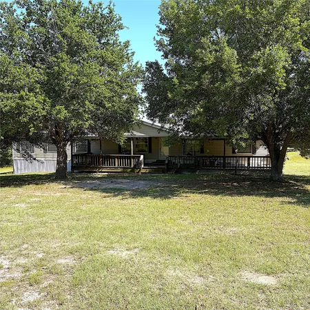 a front view of a house with swimming pool and a trees