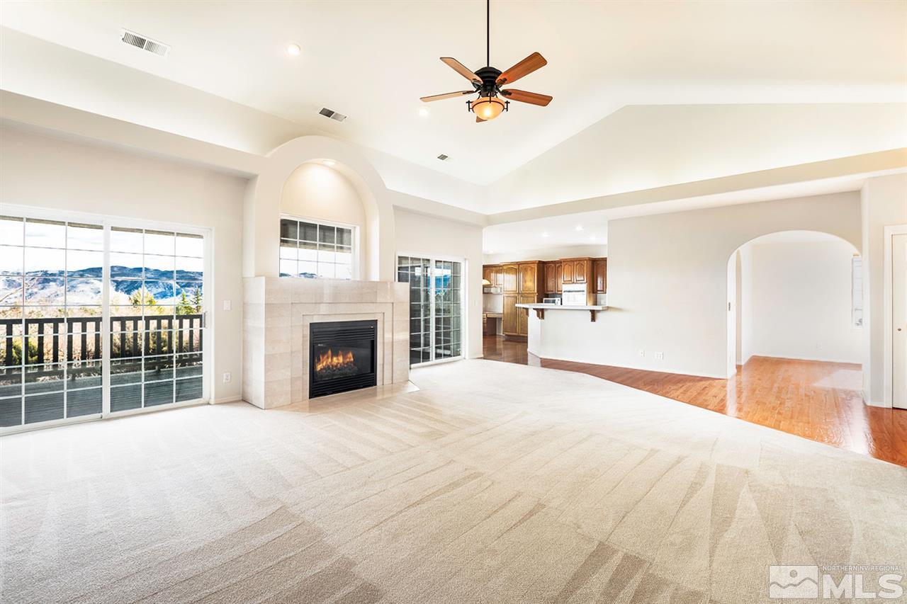 140 Gazelle Road Reno, NV 89511 - Photo 7 of 26 a view of a livingroom with a fireplace a ceiling fan and windows