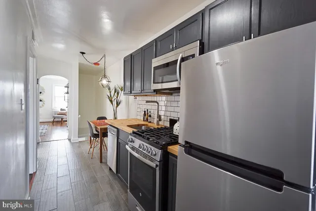 a kitchen with stainless steel appliances a refrigerator a stove and a sink