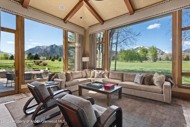 a living room with furniture and a floor to ceiling window