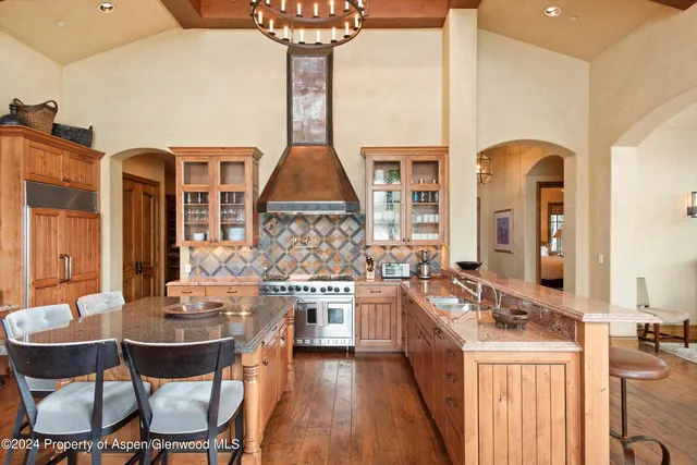 a kitchen with stainless steel appliances a stove a sink dishwasher and cabinets with wooden floor