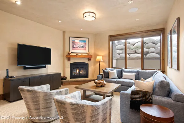 a living room with furniture a flat screen tv and a large window