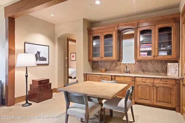 a dining hall with stainless steel appliances granite countertop a dining table and chairs with wooden floor