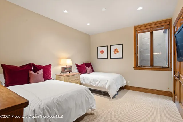 a bedroom with two beds and a window