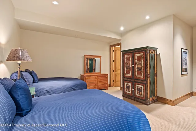 a bedroom with a bed and dresser with mirror