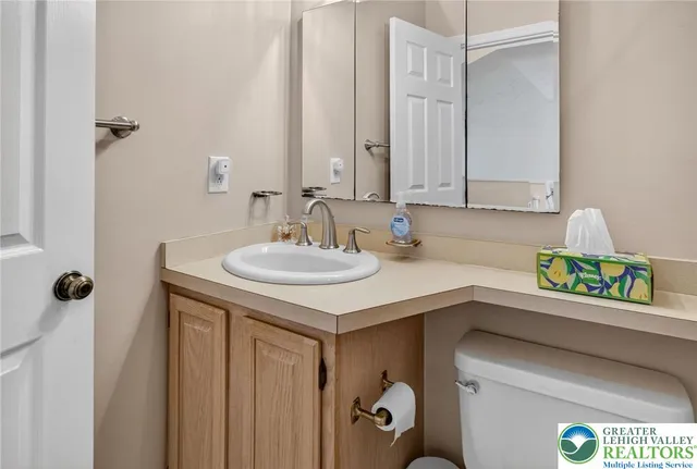 a bathroom with a granite countertop toilet sink and mirror