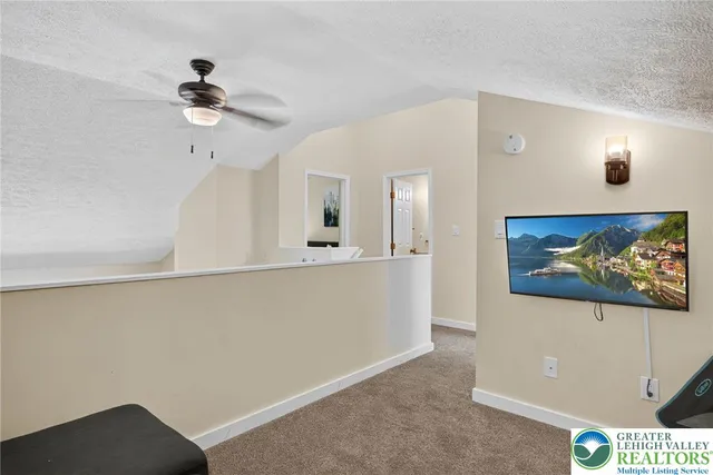a living room with furniture and a ceiling fan