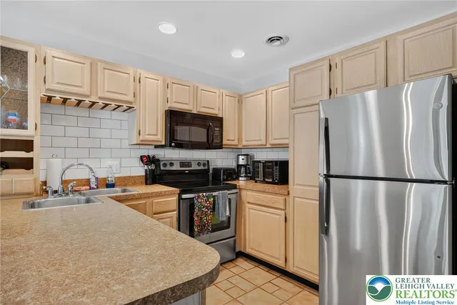 a kitchen with stainless steel appliances a refrigerator stove microwave sink and cabinets