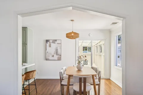 a kitchen with stainless steel appliances kitchen island granite countertop a table chairs and a refrigerator