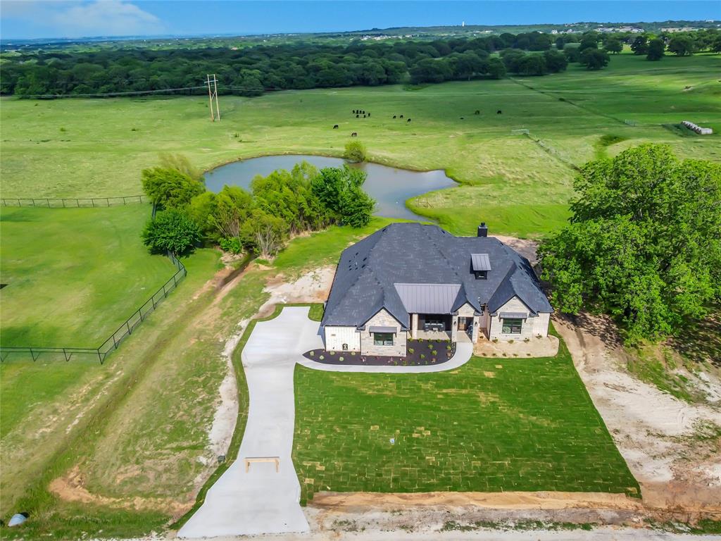 1028 Henry Way Springtown, TX 76082 - Photo 38 of 40 a view of a garden with lawn chairs under an umbrella