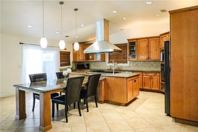 a kitchen with stainless steel appliances granite countertop a sink a stove a refrigerator a center island a stove and a cabinets