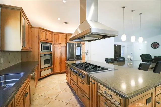 a kitchen with stainless steel appliances granite countertop a stove a sink and a refrigerator
