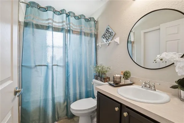 a bathroom with a sink a toilet and a mirror