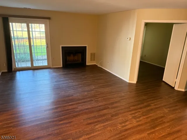 an empty room with wooden floor and a window