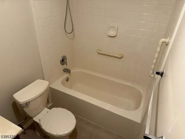 a white toilet sitting next to a bath tub
