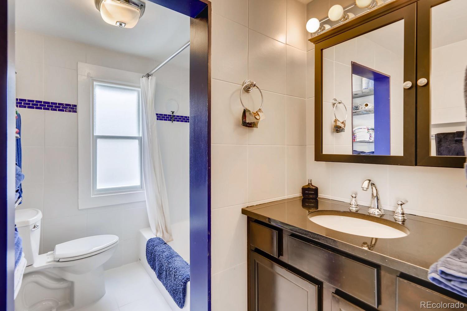 4445 Perry Street Denver, CO 80212 - Photo 11 of 19 a bathroom with a granite countertop sink toilet and shower