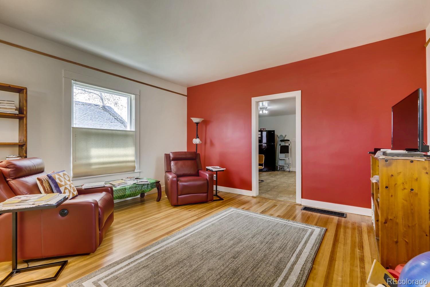 4445 Perry Street Denver, CO 80212 - Photo 2 of 19 a living room with furniture a flat screen tv and wooden floor