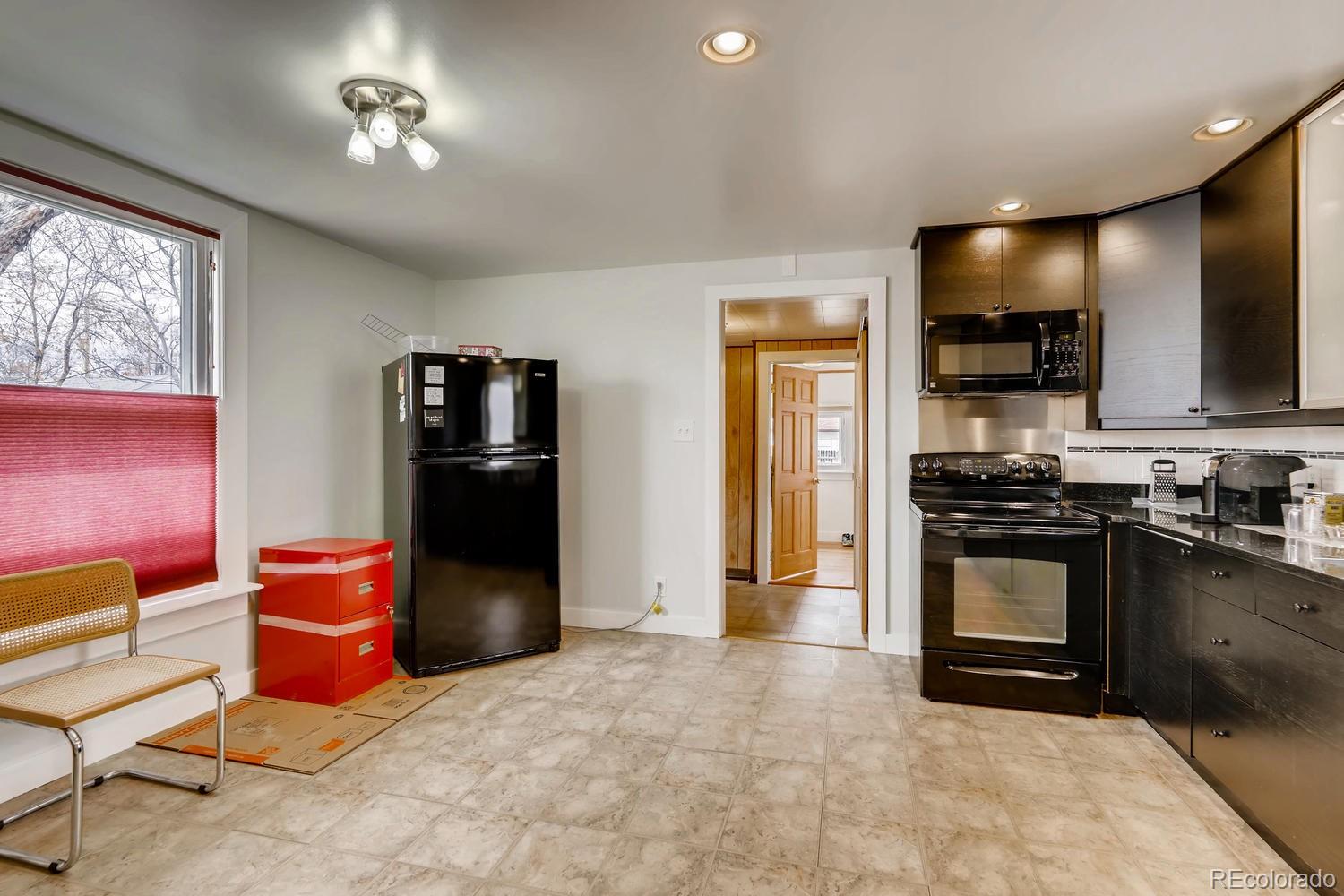 4445 Perry Street Denver, CO 80212 - Photo 6 of 19 a kitchen with stainless steel appliances kitchen island granite countertop a refrigerator and a stove top oven