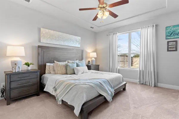 a bedroom with a bed a chandelier and a window