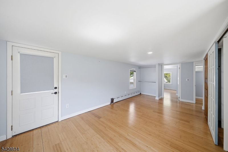 251 Russia Road Oak Ridge, NJ 07438 - Photo 17 of 34 a view of an empty room with wooden floor and a window