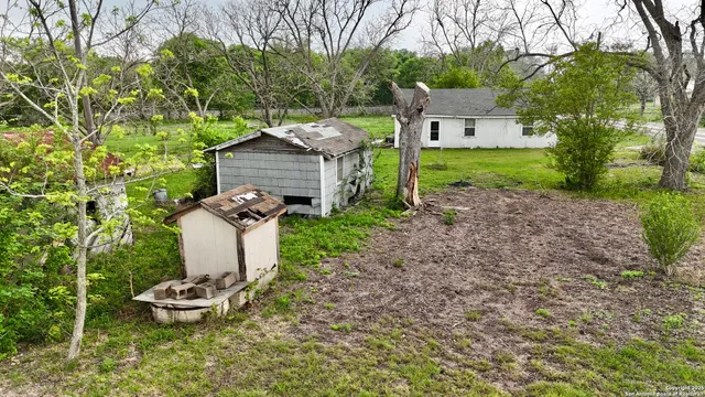 a view of a small house with a yard and furniture