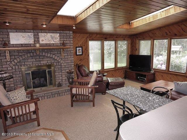 3441 Madisonville Road Moscow, PA 18444 - Photo 4 of 28 a living room with furniture a flat screen tv and a fireplace