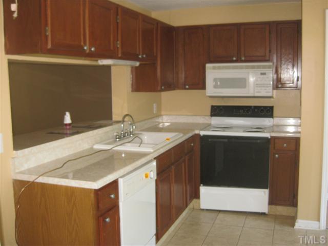 7727 Bernadette Lane Raleigh, NC 27615 - Photo 5 of 7 a kitchen with a sink a stove and cabinets