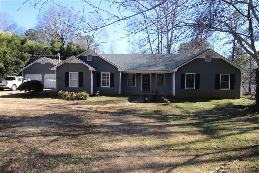 2738 Spring Street Dacula, GA 30019 - Photo 1 of 1 a front view of a house with a yard covered with trees