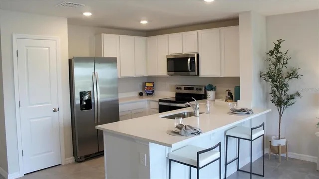 a kitchen with appliances a sink and cabinets