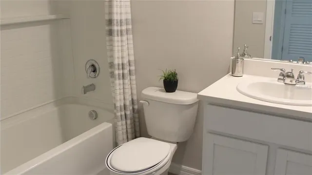 a white toilet sitting next to a bath tub