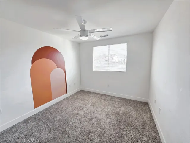 an empty room with windows and fan