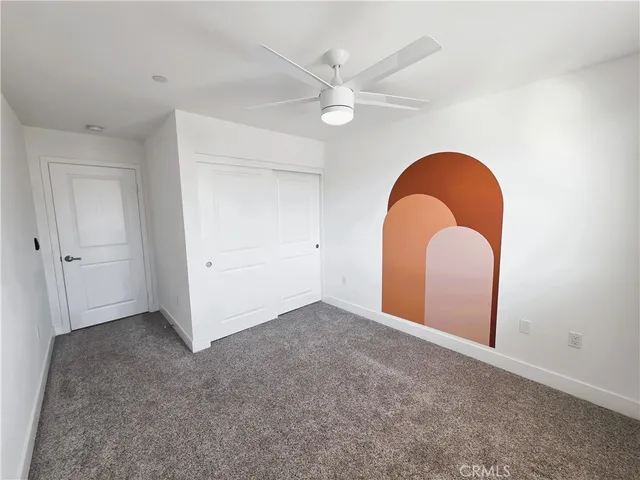 an empty room with a ceiling fan and entryway
