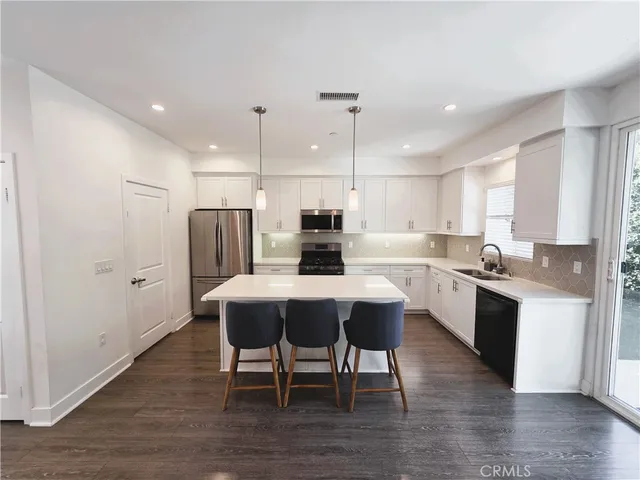a large kitchen with a table and chairs