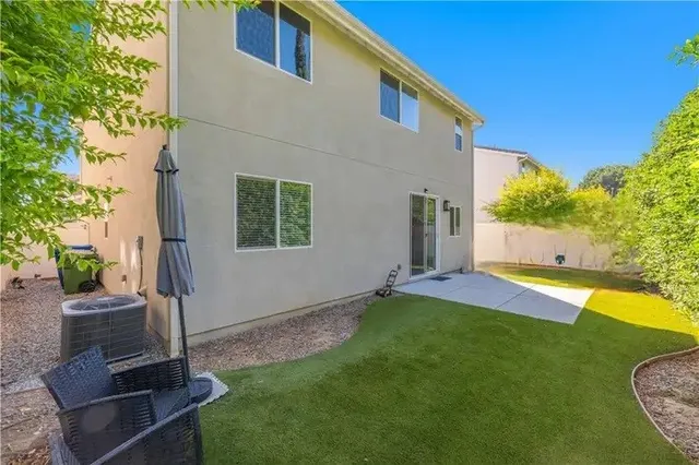 a view of a house with backyard and a tree